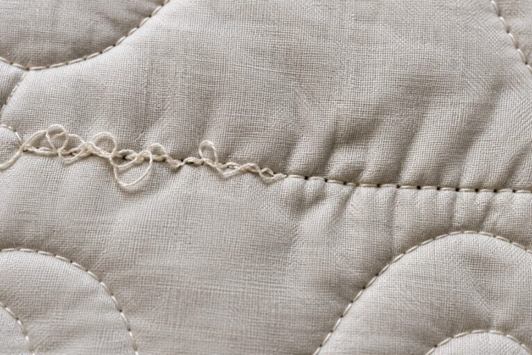 close-up of uneven, looped machine quilting stitches showing tension problems on fabric