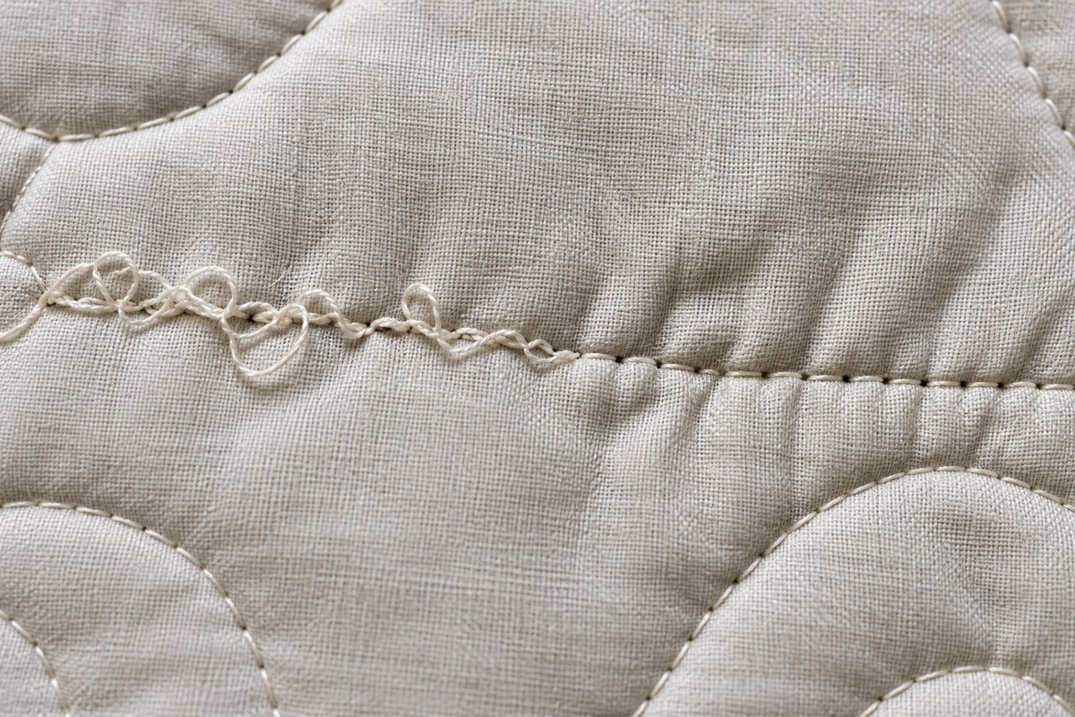 close-up of uneven, looped machine quilting stitches showing tension problems on fabric